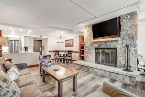 a living room with a stone fireplace with a flat screen tv at Mountain Plaza Base Camp in Copper Mountain