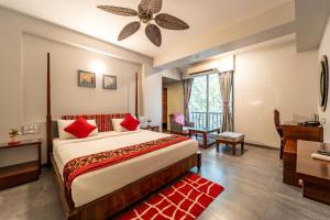 a bedroom with a large bed with a ceiling fan at Zense Candolim in Candolim