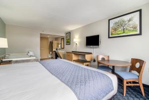 Habitación de hotel con cama grande y escritorio. en Dunes Waterfront Resort en Mears