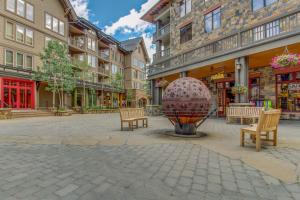 a street with benches and a large sphere in the middle at Mountain Plaza Base Camp in Copper Mountain