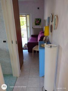 a living room with a purple couch and a table at La Casa di Ortensia in Parma