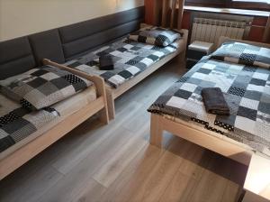 two beds in a room with wooden floors at A-Piramida in Wrocław
