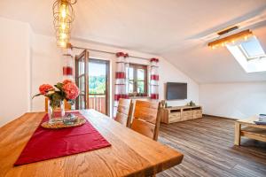 una sala de estar con una mesa de madera con flores. en Ferienwohnung Am Moosbach en Übersee