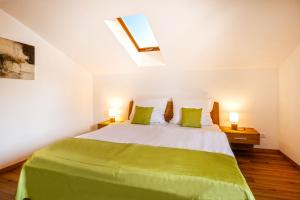 1 dormitorio con 1 cama verde y blanca con 2 lámparas en Ferienwohnung Am Moosbach en Übersee