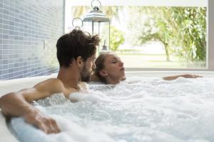 a man and a woman laying in a pool of water at Nuevo Astur Spa in Sanxenxo
