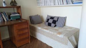 Schlafzimmer mit einem Bett mit Kissen und einem Schreibtisch in der Unterkunft Apartamento Bicho do Mar in Torres
