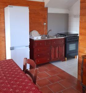 a kitchen with a stove and a sink and a refrigerator at Villa Rosa B&B in Sellia Marina