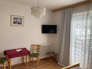 a living room with a table and chairs and a chandelier at Moserwirt Pension in Sankt Veit an der Glan