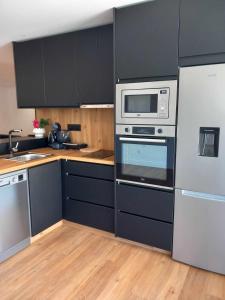 uma cozinha com electrodomésticos de aço inoxidável e armários pretos em Casa de Silvares em Celorico de Basto