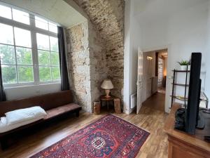 ein Wohnzimmer mit einem Sofa und einem großen Fenster in der Unterkunft Château de la Groulais in Blain