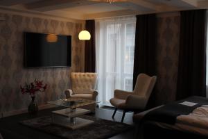Skänninge的住宿－Skänninge stadshotell，酒店客房带一张床、一台电视和椅子