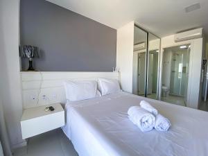 a bedroom with a white bed with towels on it at Vision Acomodação Particular na Asa Norte ao Lado do SHOPPING CONJUNTO NACIONAL COM GARAGEM - 15º andar in Brasilia