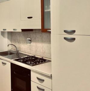 una cucina con piano cottura e frigorifero bianco di La Dolce Vita a Roma