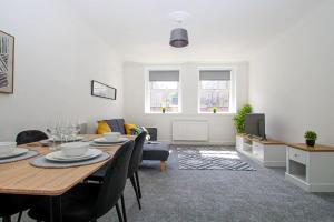a living room with a table and a dining room at Tobago St Apartment, Greenock in Greenock