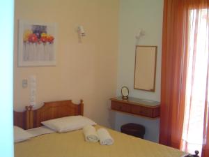 a bedroom with a bed with two towels on it at Nana Hotel in Kamena Vourla