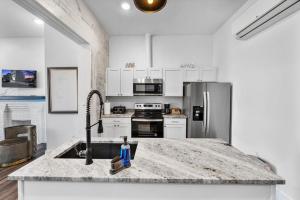 a kitchen with a sink and a stainless steel refrigerator at Brand New on the Streetcar line in Cincinnati
