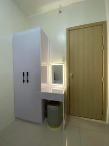ein kleines Bad mit einem Waschbecken und einer Tür in der Unterkunft Brand new 2 bedroom furnished condo unit in Vine Residences-SM Novaliches in Manila
