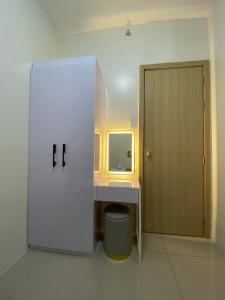 ein Badezimmer mit einem Waschbecken, einem Spiegel und einer Tür in der Unterkunft Brand new 2 bedroom furnished condo unit in Vine Residences-SM Novaliches in Manila