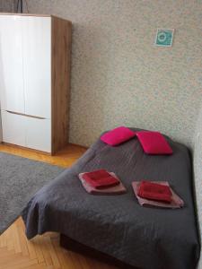 een slaapkamer met een bed met twee rode kussens erop bij Apartament Victoria in Sopot