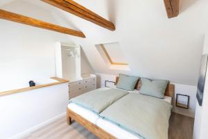 een slaapkamer met witte muren en een bed met blauwe kussens bij Altstadthäuschen in Goslar