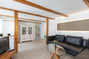 Altstadthäuschen في جوسلار: غرفة معيشة مع أريكة جلدية سوداء وتلفزيون