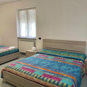 a bedroom with two beds and a window at Colle del Faggio Nature Home in Cassego