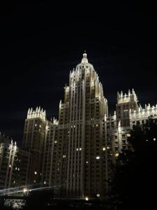 un grande edificio è illuminato di notte di Apart Hotel Триумф Астаны 22 этаж, Секция 2 a Astana