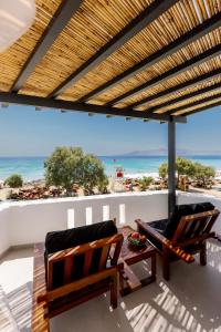 un patio con 2 sillas y una mesa y la playa en Deep blue suites, en Agios Prokopios