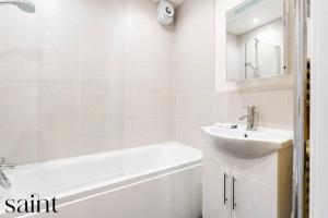 a white bathroom with a sink and a bath tub at 2BR Apartment in Central Beeston with Parking in Nottingham