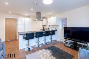 a kitchen with a counter and a bar with stools at 2BR Apartment in Central Beeston with Parking in Nottingham