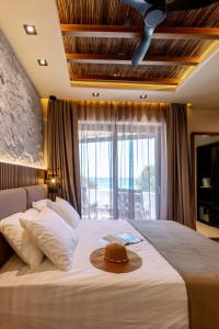 1 dormitorio con 1 cama grande con sombrero en Deep blue suites, en Agios Prokopios