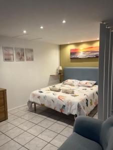 a bedroom with a bed and a painting on the wall at Au doux refuge in Drouvin-les-Marais
