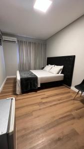 um quarto com uma cama e piso em madeira em Hotel Diamante em São Paulo