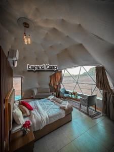 a bedroom with a large bed and a large window at Rum Legend camp in Wadi Rum