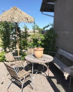 a table and chairs with a potted plant and an umbrella at Bo på Kvarnen in Varberg