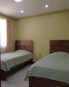 1 dormitorio con 2 camas y ventana en Departamento Frente a la Plaza Sucre de Tarija, wifi, ascensor, garaje extra, en Tarija