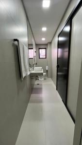 a bathroom with a long hallway with a sink and a mirror at Hotel Diamante in Sao Paulo