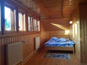 1 dormitorio con 1 cama en una habitación de madera en Cabana Cheia Fericirii - Forest Family Retreat, en Cheia