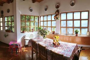 a dining room with a table and some windows at Cabana Cheia Fericirii - Forest Family Retreat in Cheia