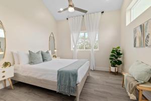 a white bedroom with a bed and a window at Davis Shores Lookout- Dog Friendly Mins to DNTN & Beach in St. Augustine
