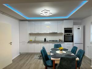 a kitchen with a table and blue lights on the ceiling at ZIM Family Airport in Otopeni