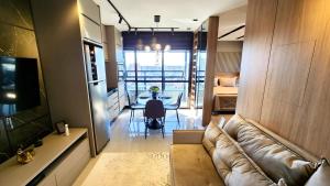 a living room with a leather couch and a table at Luxury Collection By Vertigo 23º Floor in Campo Grande
