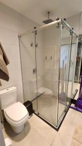 a bathroom with a toilet and a glass shower at Luxury Collection By Vertigo 23º Floor in Campo Grande