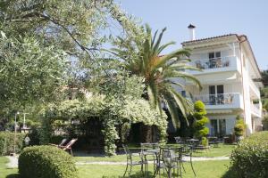 een hotel met tafels en stoelen voor een gebouw bij Porto Psakoudia in Psakoudia
