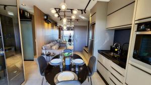 a dining room with a table and chairs and a couch at Luxury Collection By Vertigo 23º Floor in Campo Grande
