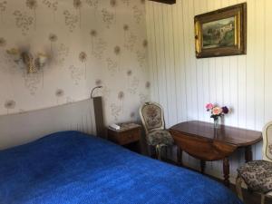 a bedroom with a bed and a table and chairs at chambres d'hôtes du puy blanc in Saint-Paul