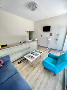 Hostal Lumar في بارانكويلا: غرفة معيشة مع أريكة زرقاء وتلفزيون