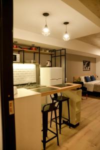 cocina con encimera y taburetes en una habitación en Distrito A FMA-Coliving en Salta