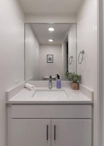 a white bathroom with a sink and a mirror at Spacious Retreat w Private Roof Deck Walkable to ALL in Cincinnati +62 photos