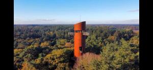 een oranje toren midden in een bos bij Appelscha aan de diek in Appelscha